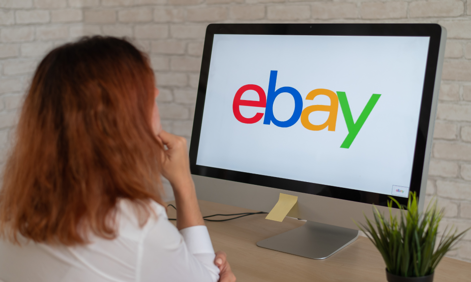 Woman sat at her computer with eBay on the screen